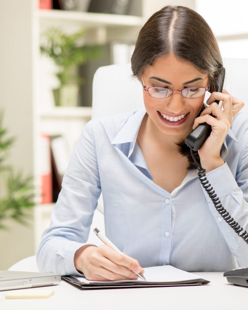 Businesswoman Phoning In The Office A young beautiful businesswoman sitting in the office and phoning.